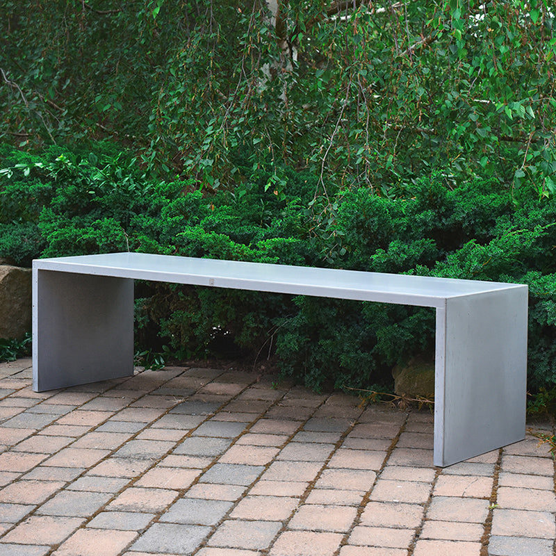 Длинная бетонная скамейка на открытом воздухе 